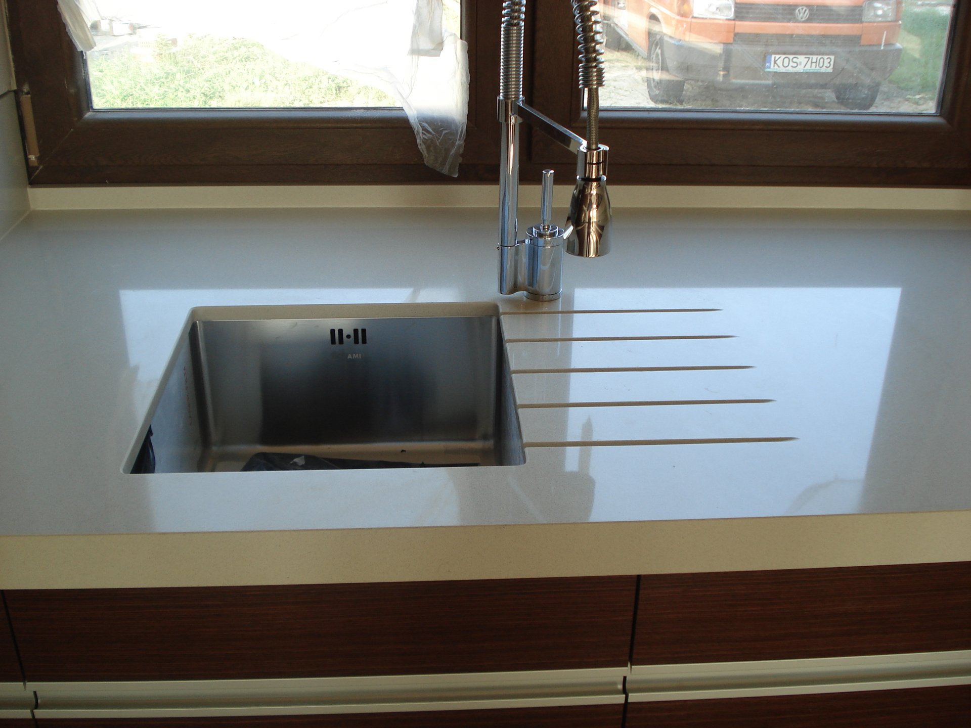 Biały granitowy blat na wyspie w nowoczesnej kuchni