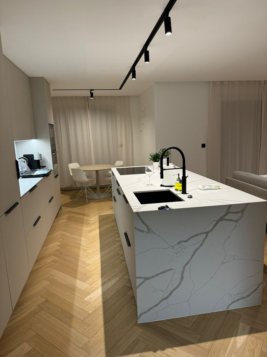 Nowoczesna kuchnia z białym granitowym blatem i wyspą kuchenną