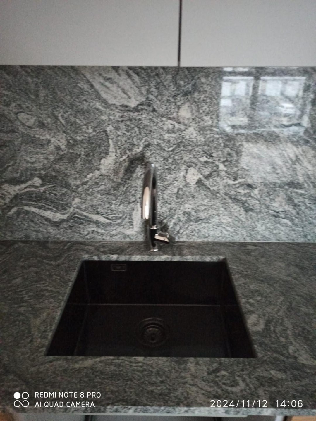 Jasny granitowy blat kuchenny w nowoczesnej, jasnej kuchni